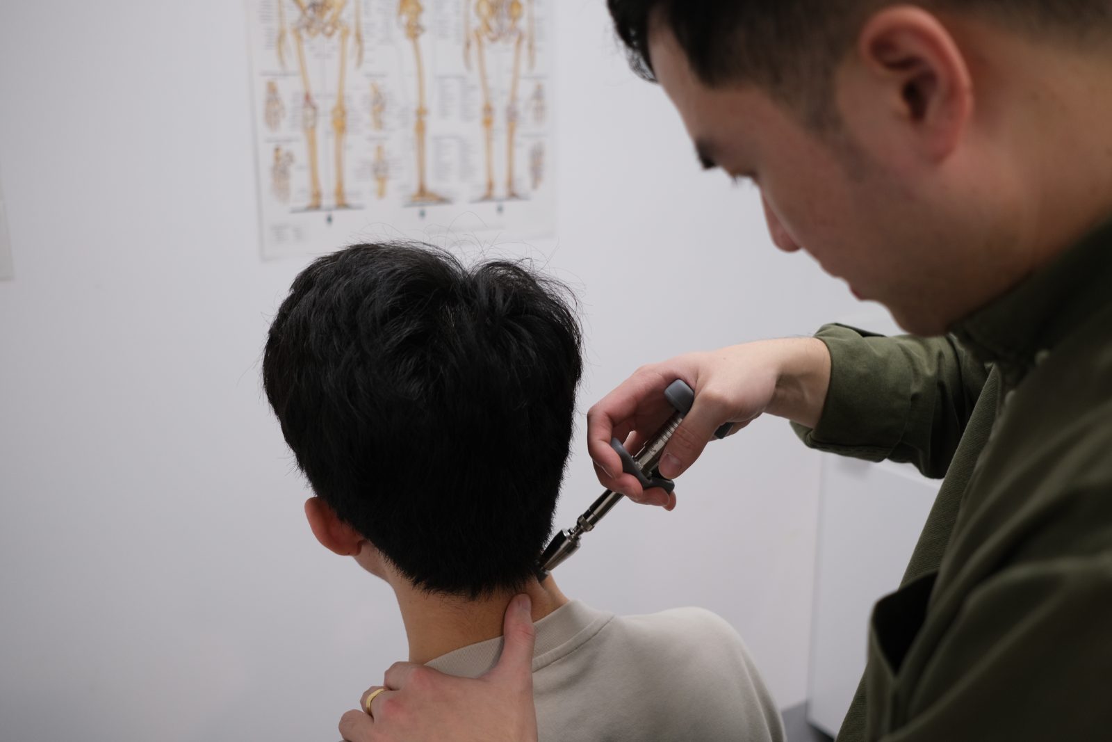 Chiropractor using an Activator instrument on a patient&rsquo;s neck at Langford Chiropractic