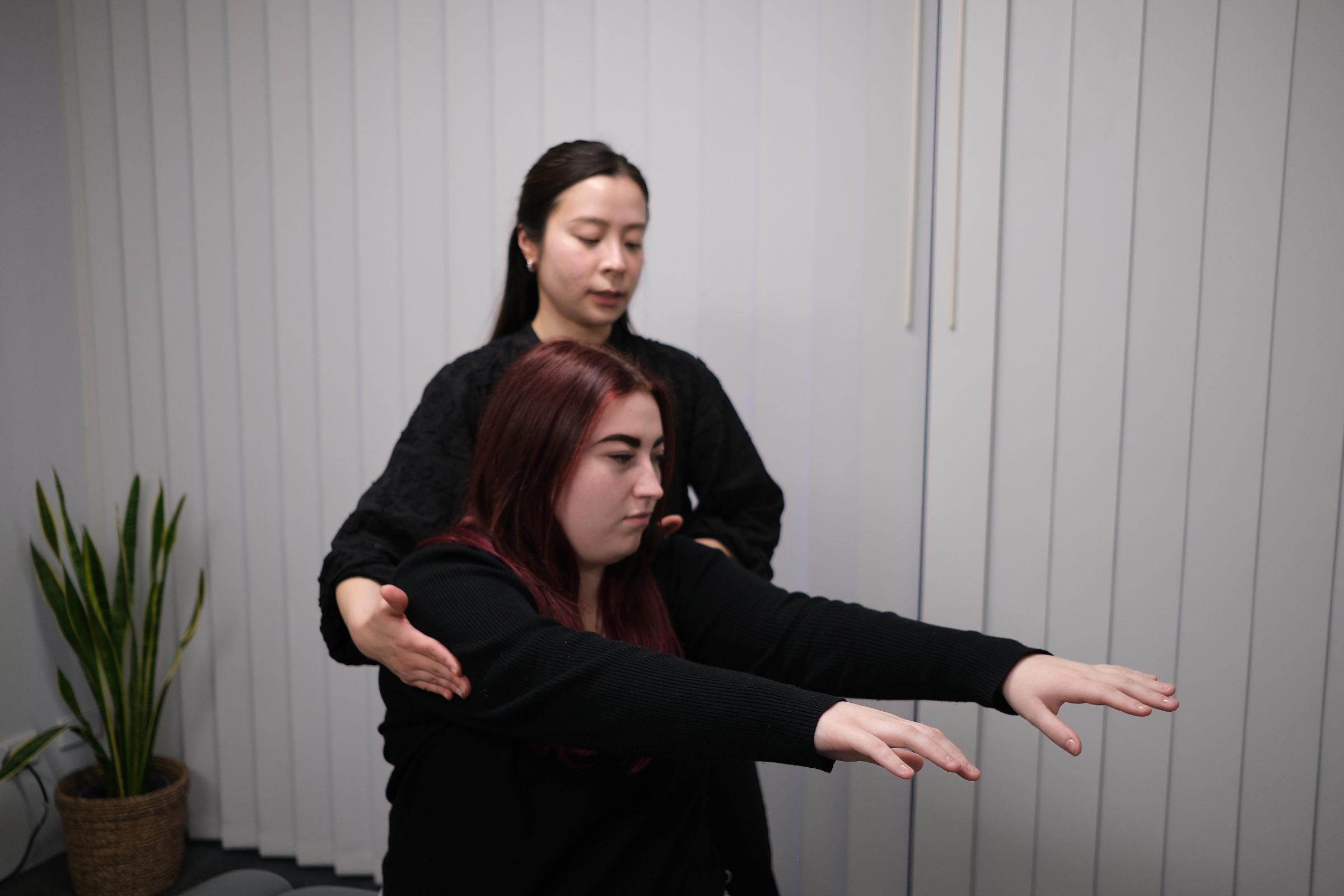 Chiropractor assessing a seated patient&rsquo;s arm and shoulder balance at Langford Chiropractic